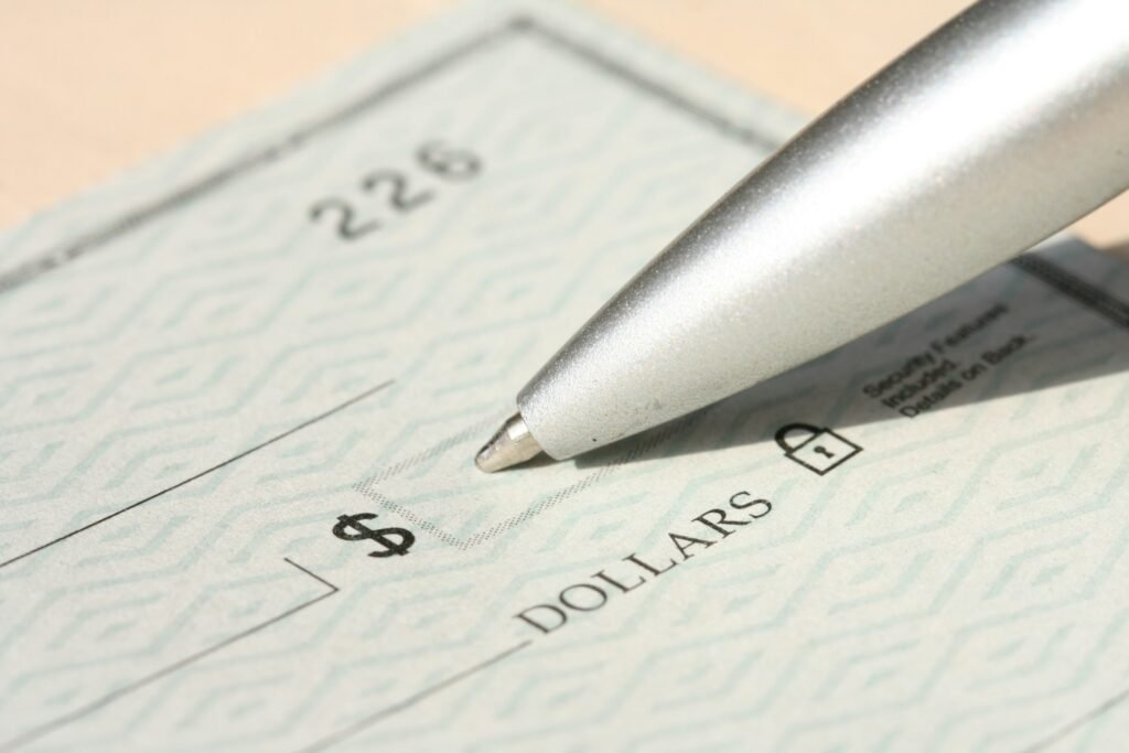 Pen resting on a bank check ready to write