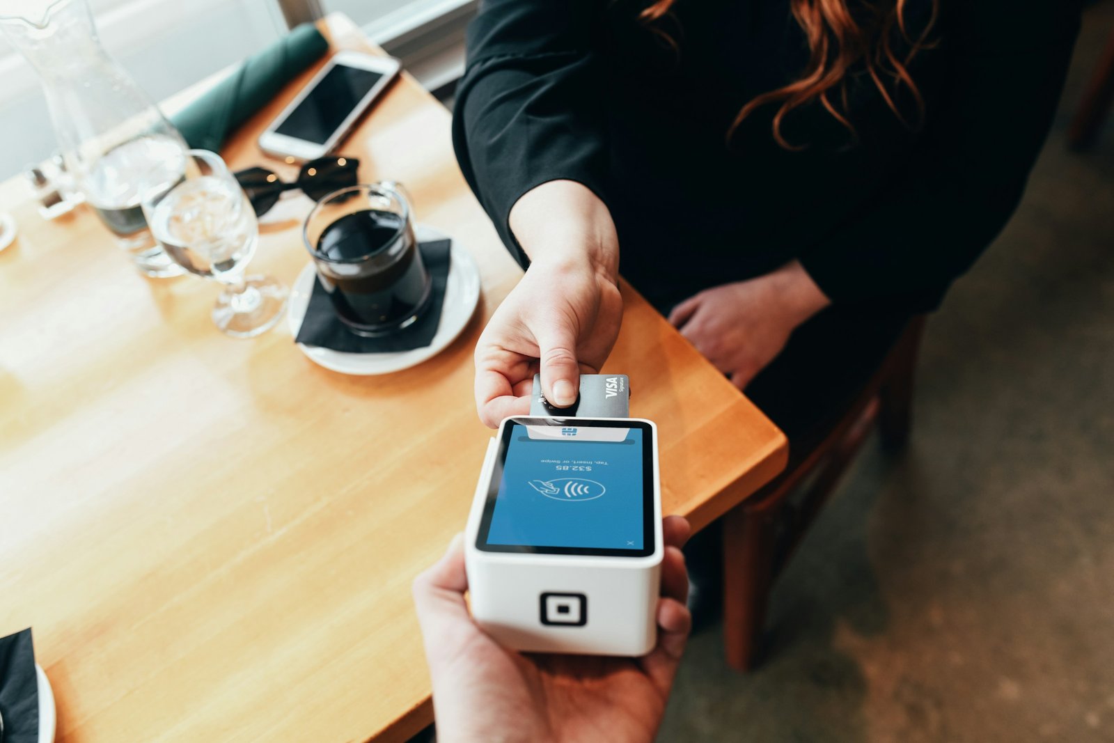 Person holding a card swipe machine for in-person payment