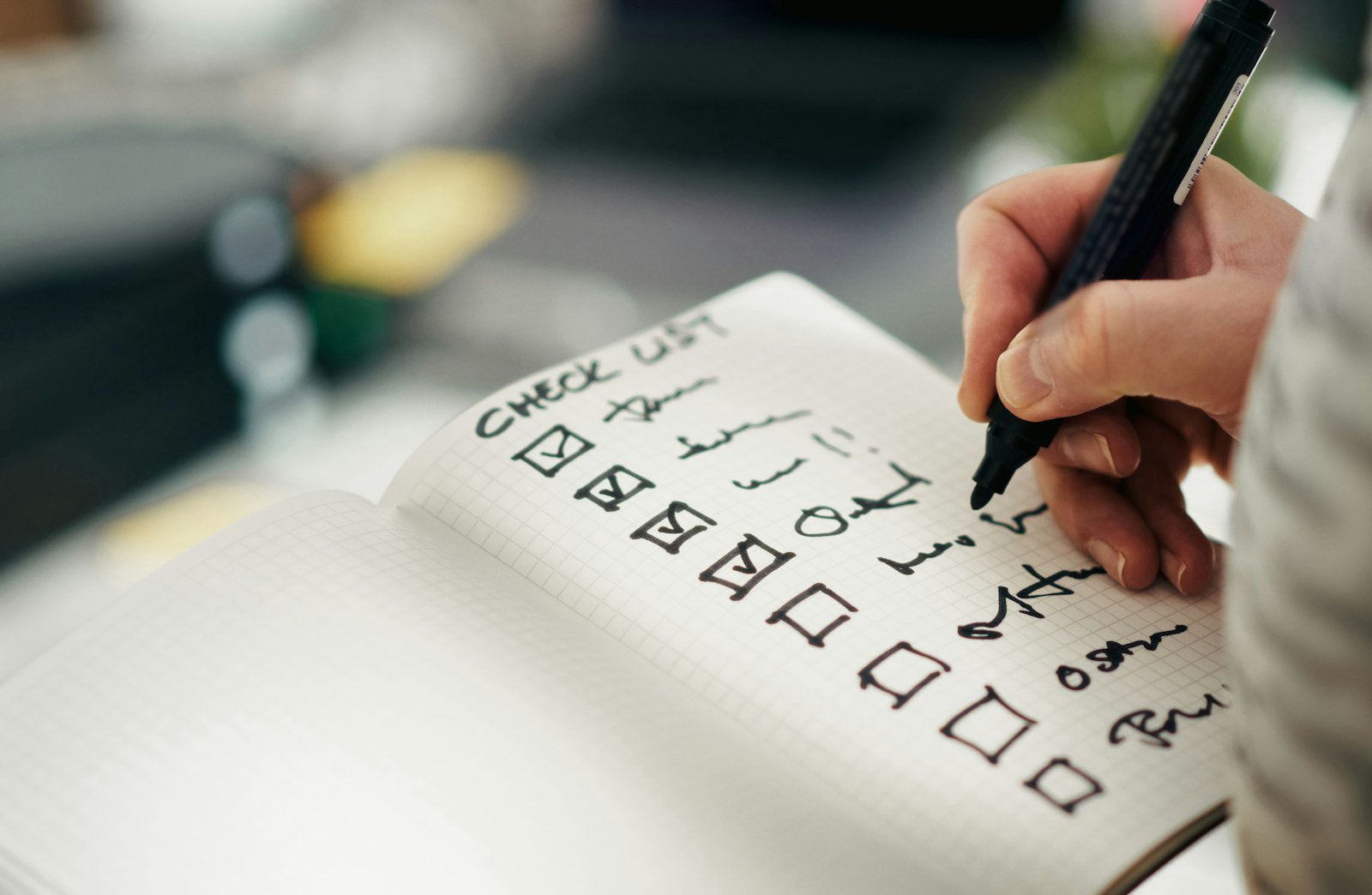 Person ticking items off a checklist during a bookkeeping cleanup