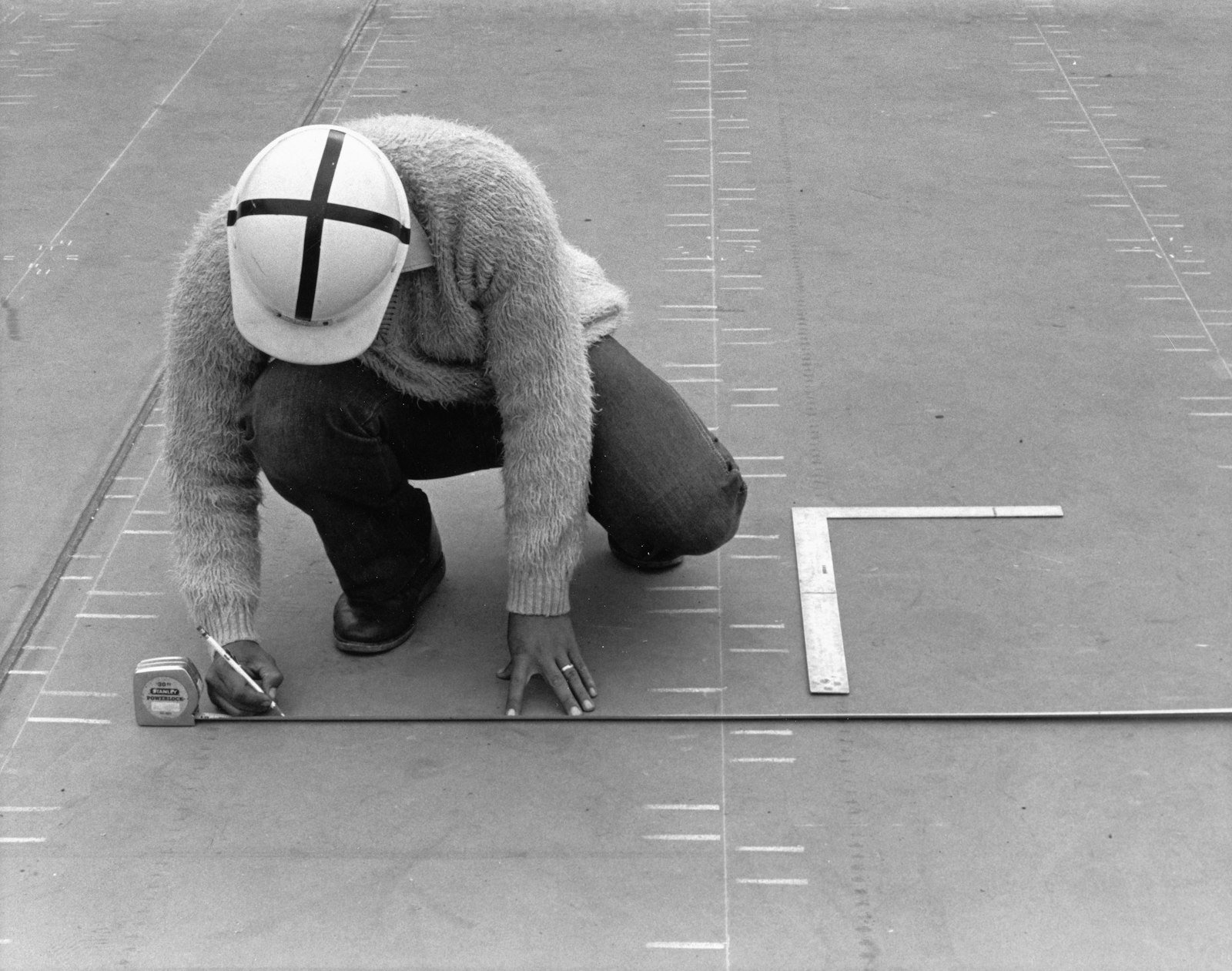 Worker measuring a surface with a tape measure and pencil
