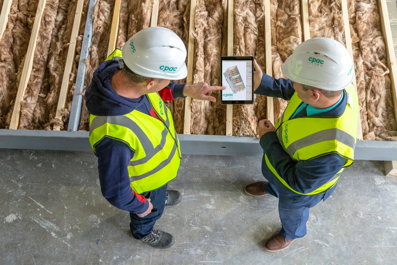 Two construction workers reviewing plans on a tablet while choosing the best accounting software for contractors