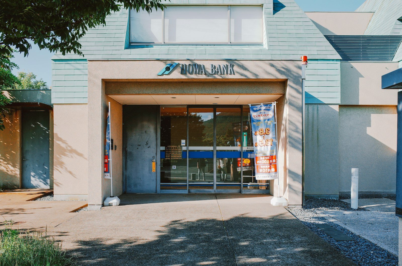 Modern bank entrance with glass doors and signage