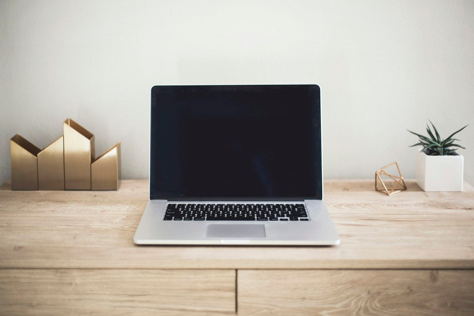 MacBook open on a desk while checking QuickBooks Online performance