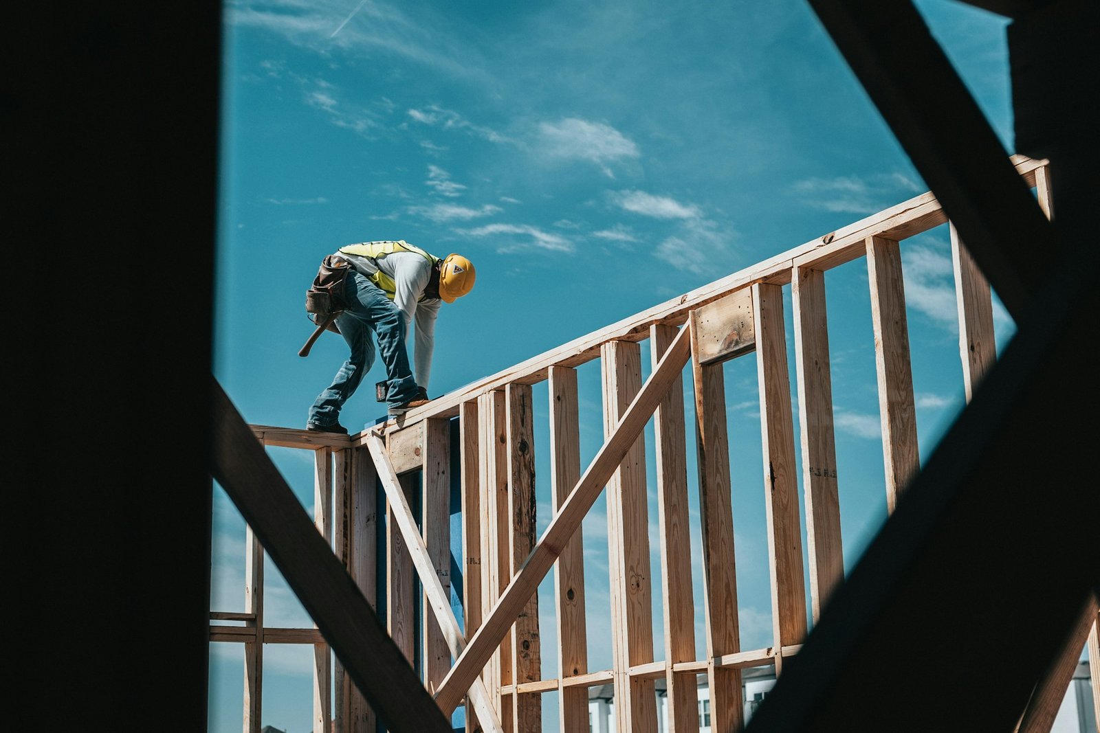 Construction worker wearing a hard hat in a building frame