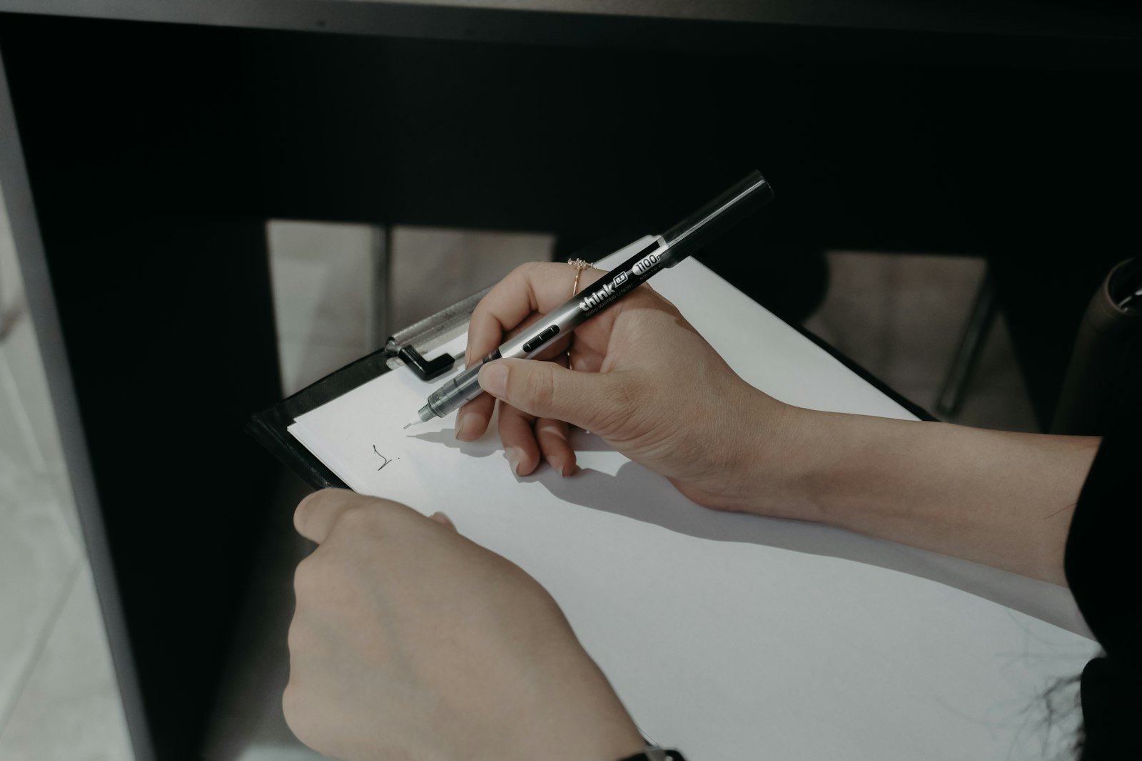 Hands writing on a clipboard during a physical count, part of how to track inventory in QuickBooks Online