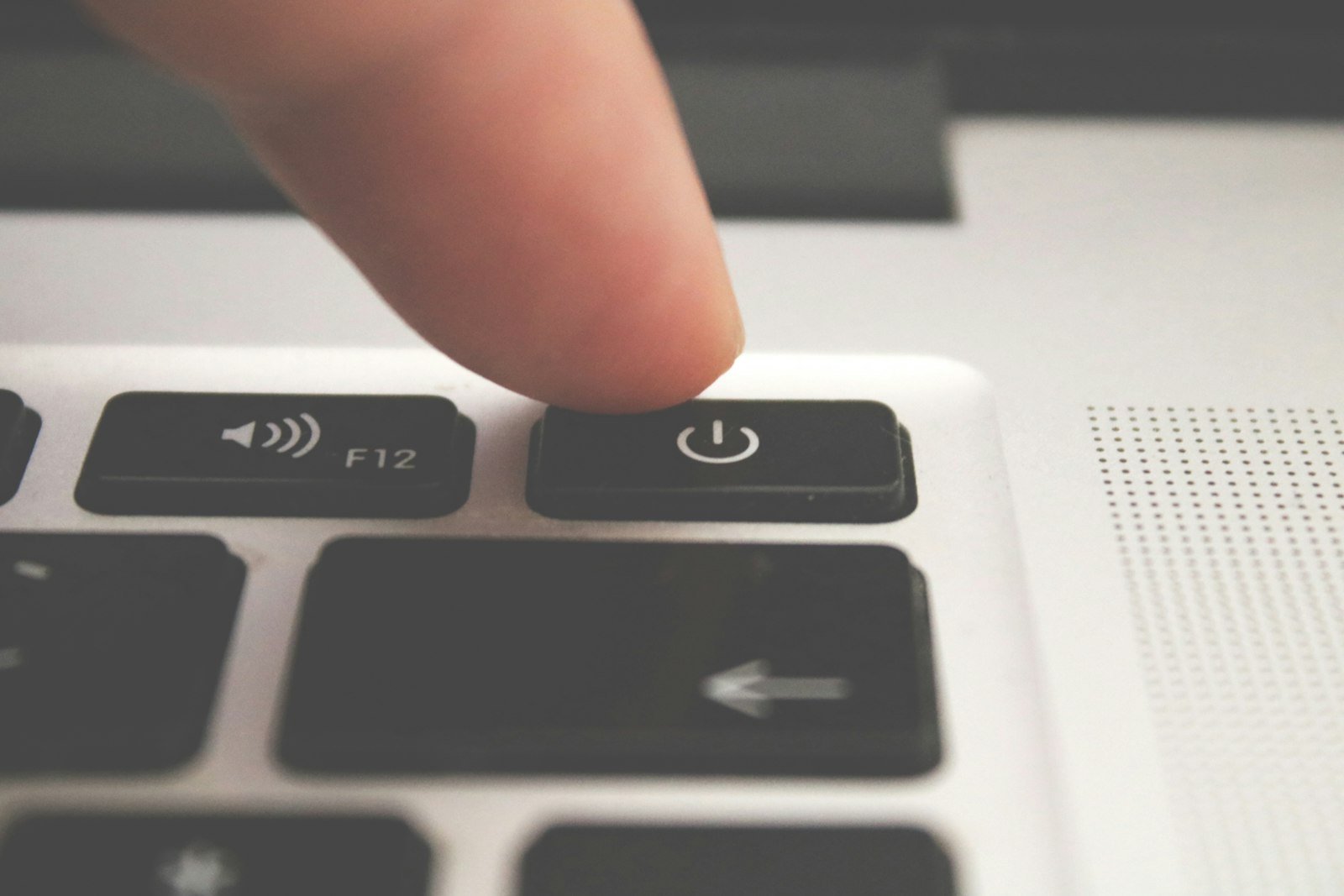 Close-up of a finger pointing at a power switch, the first step to try when QuickBooks will not open