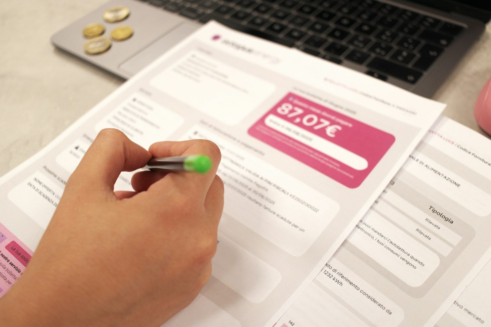Person reviewing an unpaid invoice with a pen before deciding to write off bad debt in QuickBooks