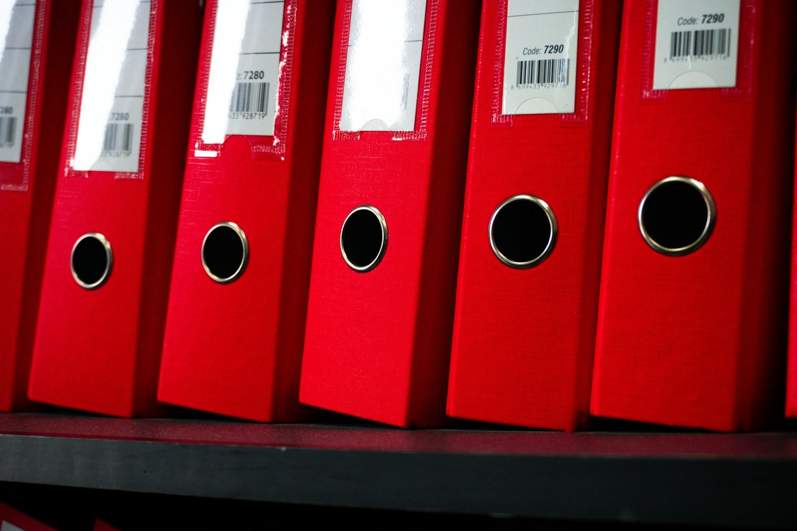 Red file folders organized neatly on a shelf