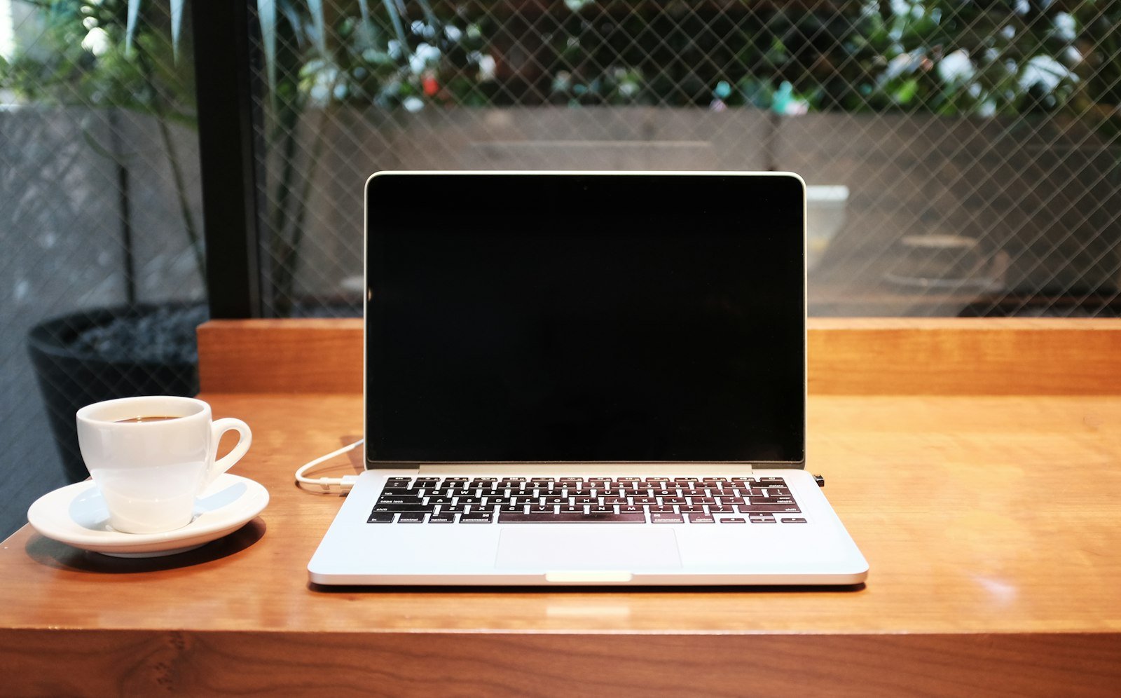 Laptop next to a cup of coffee on a desk