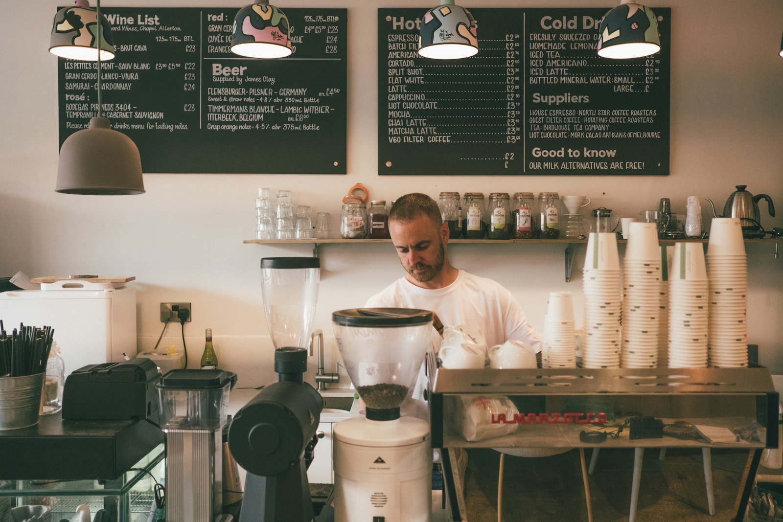 Man in a white dress shirt standing behind a shop counter