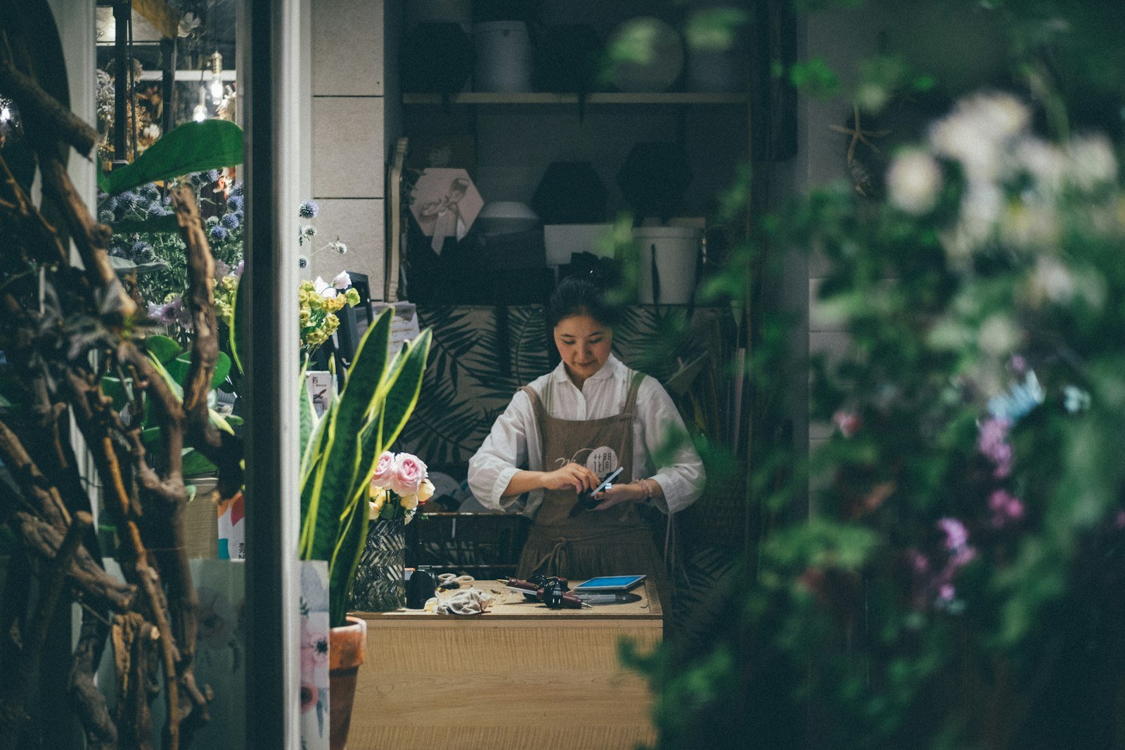 Woman standing at a table, a small business owner deciding how to pay herself